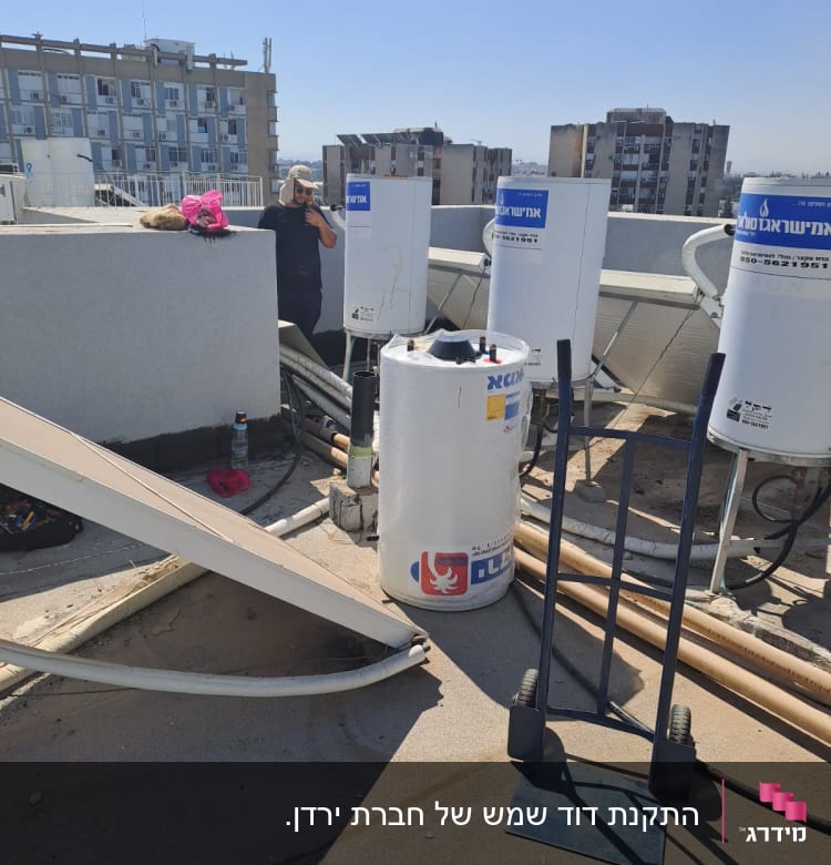 דודי שמש על גג עם צינורות ומתקן מתכת